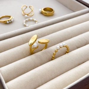 Close-up of golden freshwater pearl ring set displayed in a beige velvet jewelry box
