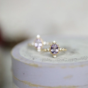 Macro shot of oval amethyst ring with 14K gold vintage milgrain detailing and pavé diamonds