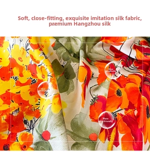 Close-up detail of soft floral silk-like scarf fabric with yellow and red flower prints