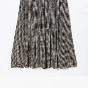 Detailed view of classic houndstooth pleated midi skirt in black, brown and white tones