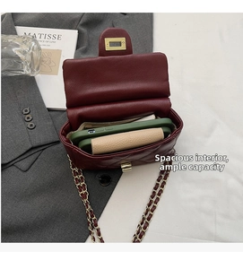 Deep red quilted handbag with gold lock and chain strap showing interior storage space