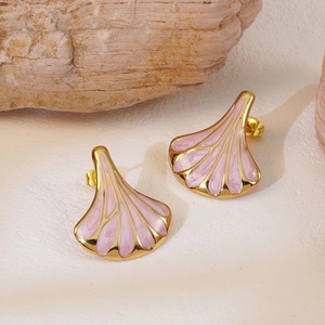 Macro detail of vintage fan-shaped gold earrings with pink marble texture on stone base