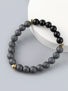 Men's beaded bracelet featuring matte grey and black glossy beads with gold metal accents