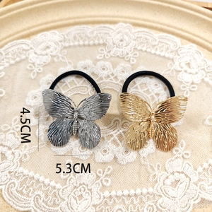 Detailed view of metallic gold and silver butterfly hair ties with dimensions 5.3cm by 4.5cm