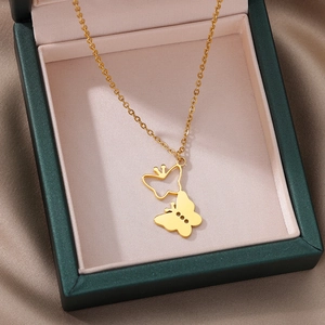 Detail shot of golden 18k stainless steel double butterfly pendant in an elegant gift box
