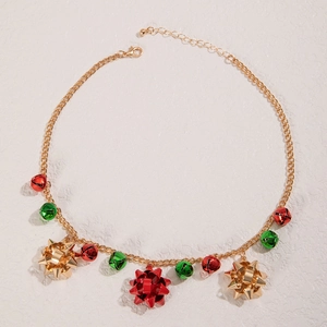 Détail du collier de Noël avec cloches rouges et vertes et pendentifs noeuds dorés