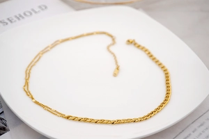 Detail of a gold titanium steel necklace featuring a chunky Cuban chain and double link design