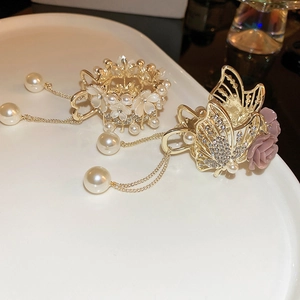 Detailed view of elegant gold flower hair claws with pearl tassels and rhinestones