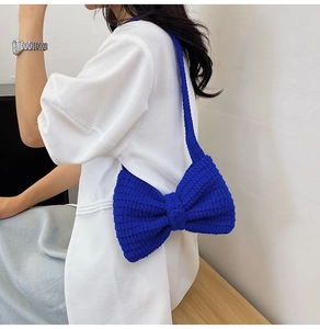 Détail du sac à bandoulière en crochet bleu roi avec grand nœud et texture tricotée