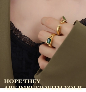 Detail of a 18K gold ring set featuring an emerald green zircon and chain link design