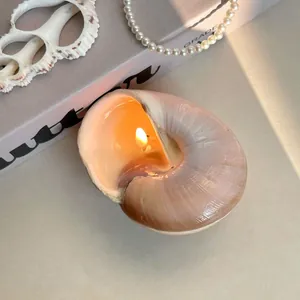 Macro shot of seashell scented candle with light pink wax and natural shell texture