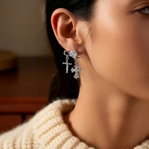 Silver safety pin earrings with zircon cross pendants on a model for a stylish look