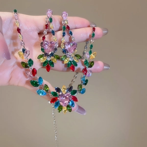 Macro shot of silver jewelry set with pink heart stone and colorful marquise zircons
