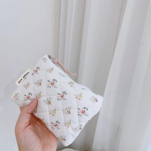 Détail du porte-monnaie matelassé à fleurs avec étiquette Simple Wish et fermeture éclair