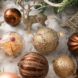 Golden and bronze Christmas ball ornaments set with reindeer decorations in snow scene