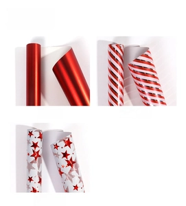 Detailed view of gift wrapping paper rolls in solid red, stripes, and star patterns