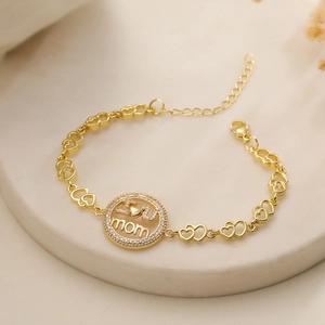 Detail of 18K gold plated MOM bracelet with heart links and crystal heart charm