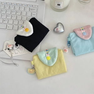 Détail de mini pochettes en tissu avec boutons-pression et pendentifs animaux mignons