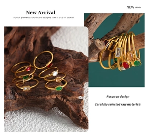 Detailed view of vintage gold-plated rings with colorful gemstones on rustic wood and branches