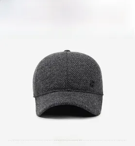 Detailed view of dark grey wool blend fabric and metal logo on winter baseball cap