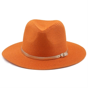 Detail of orange straw fedora hat featuring a thin champagne gold belt and metal buckle