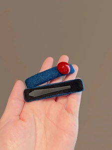 Detail of blue fabric hair clip with red beads and metal duckbill clip back view
