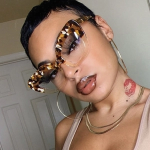 Detail of leopard print cat eye frames paired with golden hoop earrings and necklace