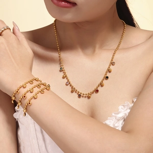 Ensemble collier et bracelet dorés 18 carats avec perles en verre coloré chic