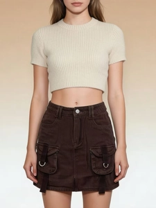 Detailed view of dark brown denim cargo skirt with large utility pockets and metal D-ring