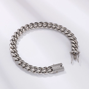 Close-up of silver Cuban link bracelet featuring a luxury diamond-set square clasp