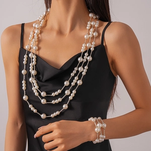 Détail d'un collier triple rang en perles crème et son bracelet multi-rangs assorti
