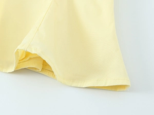 Dettaglio del top in popeline giallo pallido con cuciture sottili e trama del tessuto