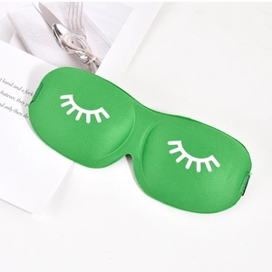 Detail of green 3D sleep mask featuring white eyelash patterns and adjustable strap