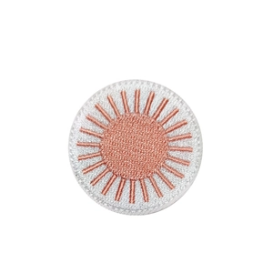Round sun embroidery patch with light pink rays and white fabric base for clothing