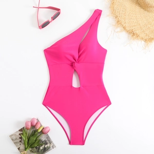 Detail of pink one-shoulder swimsuit with waist knot cutout and summer beach accessories
