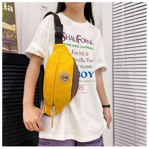 Detailed view of a yellow and brown color-block crossbody bag with adjustable strap