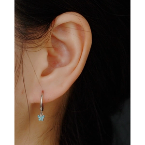 Detail of silver S925 butterfly hoop earring with turquoise stone on ear