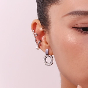 Detail of silver J-shape ear cuffs with pearls and zircon set on model ear