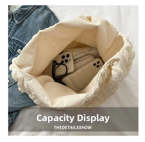Vue de dessus du sac cabas en toile crème montrant la grande capacité pour accessoires