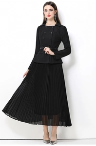 Détail d'une robe manteau noire à double boutonnage avec jupe plissée et ceinture