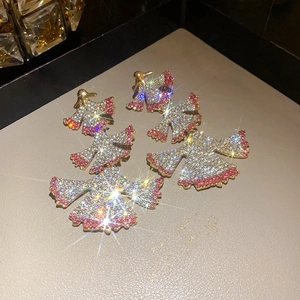 Detailed close-up of luxurious fan-shaped drop earrings with pink and white rhinestones