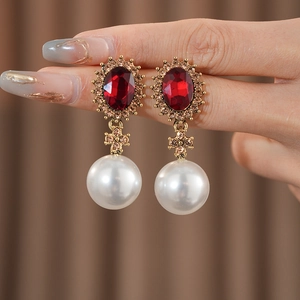 Détail de boucles d'oreilles vintage en or avec rubis, cristaux et perles