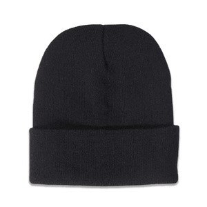 Gros plan sur la texture en tricot et le revers plié du bonnet noir d'hiver