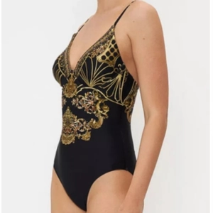 Side view of one-piece swimsuit featuring black fabric and golden Baroque patterns