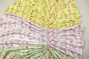 Detailed view of satin fabric with polka dot print and ruching in three colors