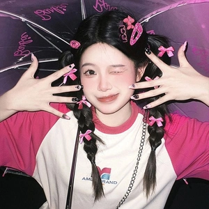 Close-up of pink bow hair clips and ribbon accessories on model for Y2K style