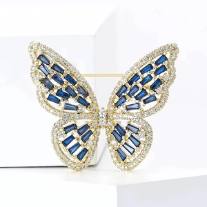 Detail of elegant butterfly brooch with blue crystals and zircons on gold metal