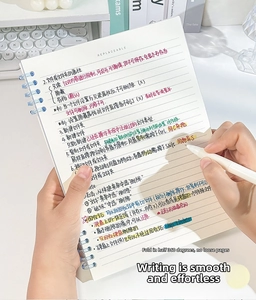 Close-up of hands writing in a transparent blue spiral binder notebook on a white desk