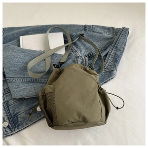 Detail der armee-grünen Nylon-Beuteltasche mit schwarzem Netzfach und grauem Schultergurt