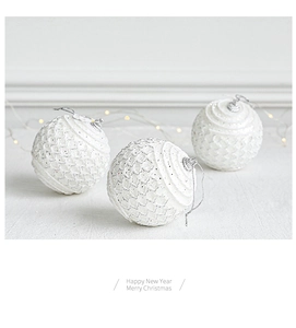 Close-up of white lace Christmas balls with silver glitter and scale-like texture